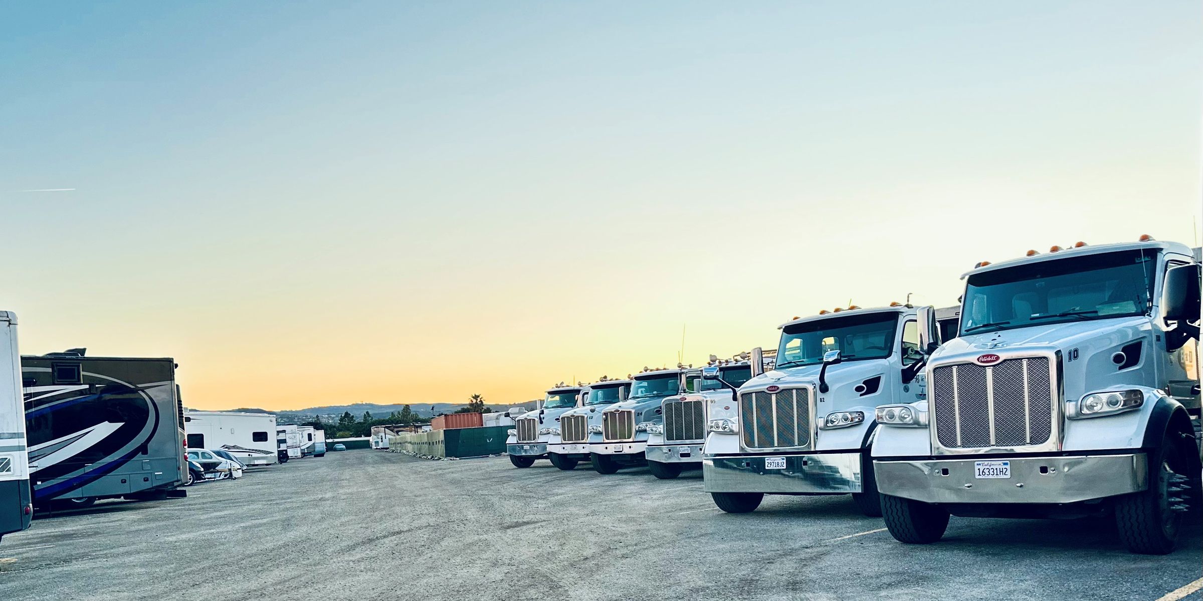 The B&D Transportation dump truck fleet lined up at sunrise in Southern California